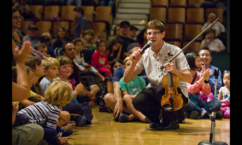 Violinist Ben Tomkins gets in touch with the Festival’s youngest audience members during the Free Family Concert string demonstration. Photo: rr jones