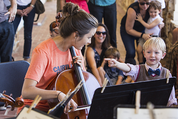 A young audience member plays "find the cellist" with Jennifer Humphreys during the Free Family Concert's Tour of the Orchestra. Photo by rr jones.
