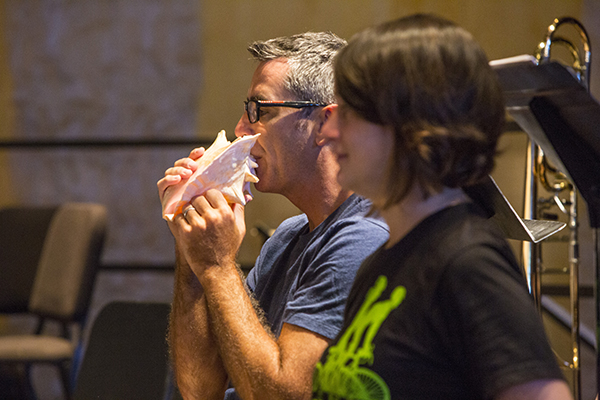 Principal trumpet Craig Morris blows a conch shell in rehearsal for Huang Ruo's The Color Yellow. Photo by rr jones.