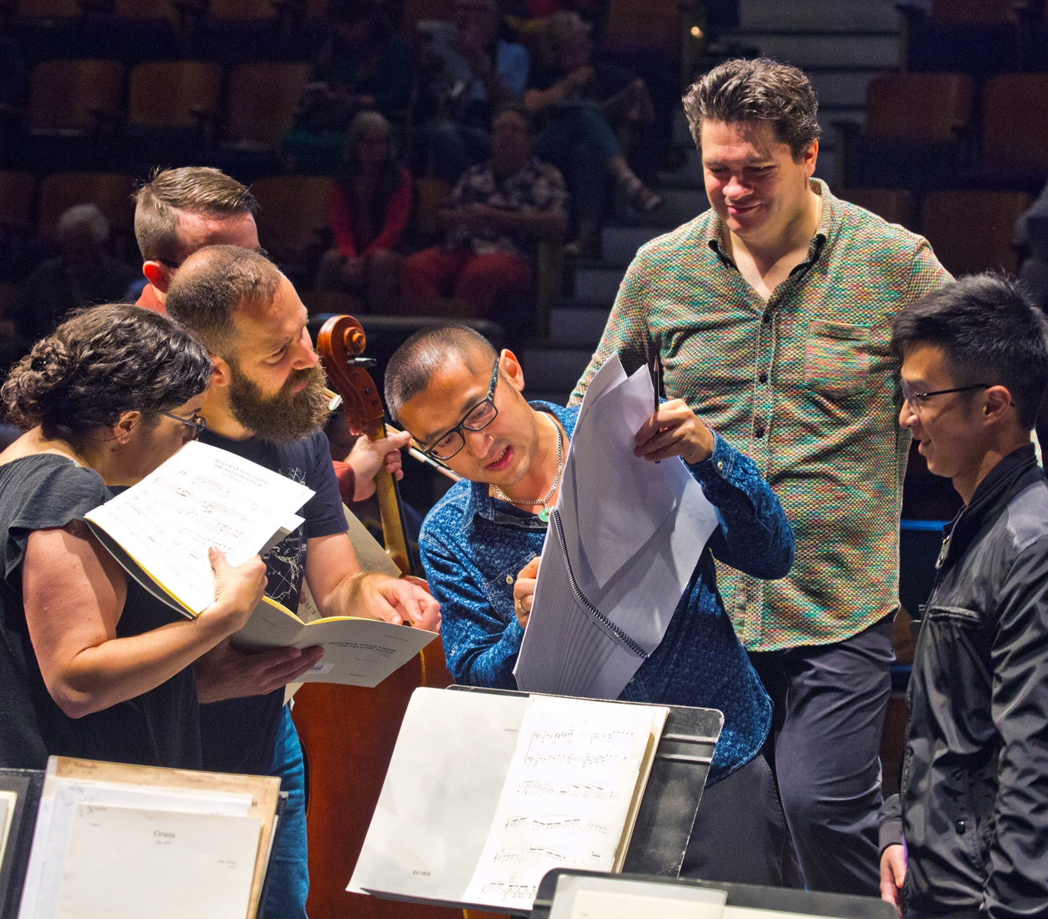 Composer Huang Ruo reviews his score with orchestra players.
