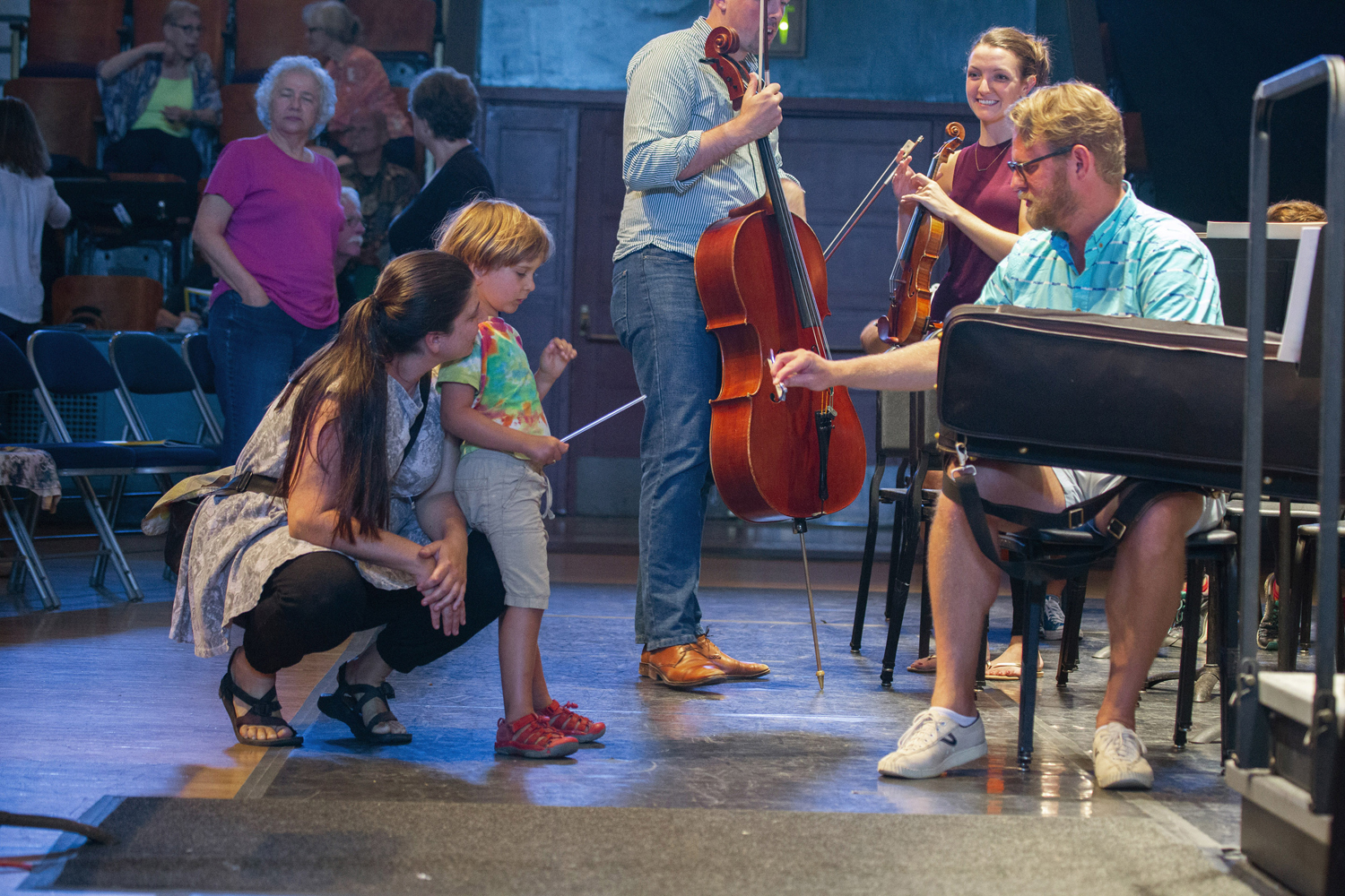 Concertmaster Justin Bruns demonstrates bow technique to a young open rehearsal attendee.