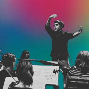 A young male conductor conducting an orchestra